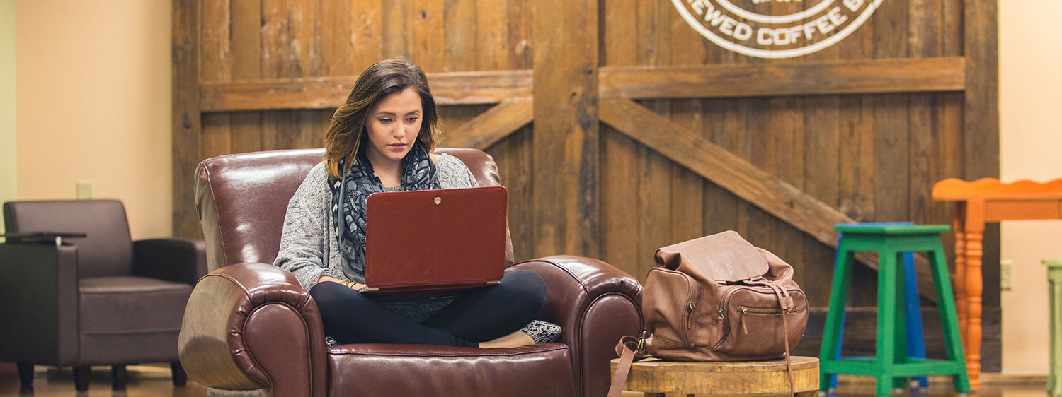 A student studies on her laptop at the Regent University lounge.