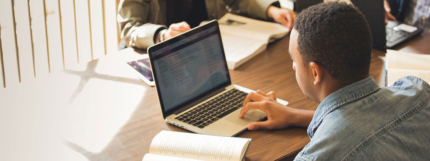 A student studies on his laptop at Regent University's library.