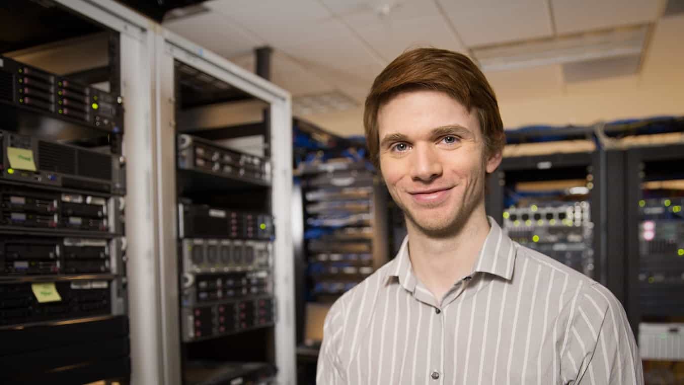 A student in a server room: Pursue Regent's B.S. in Management Information Systems degree online or in Virginia Beach, VA 23464.