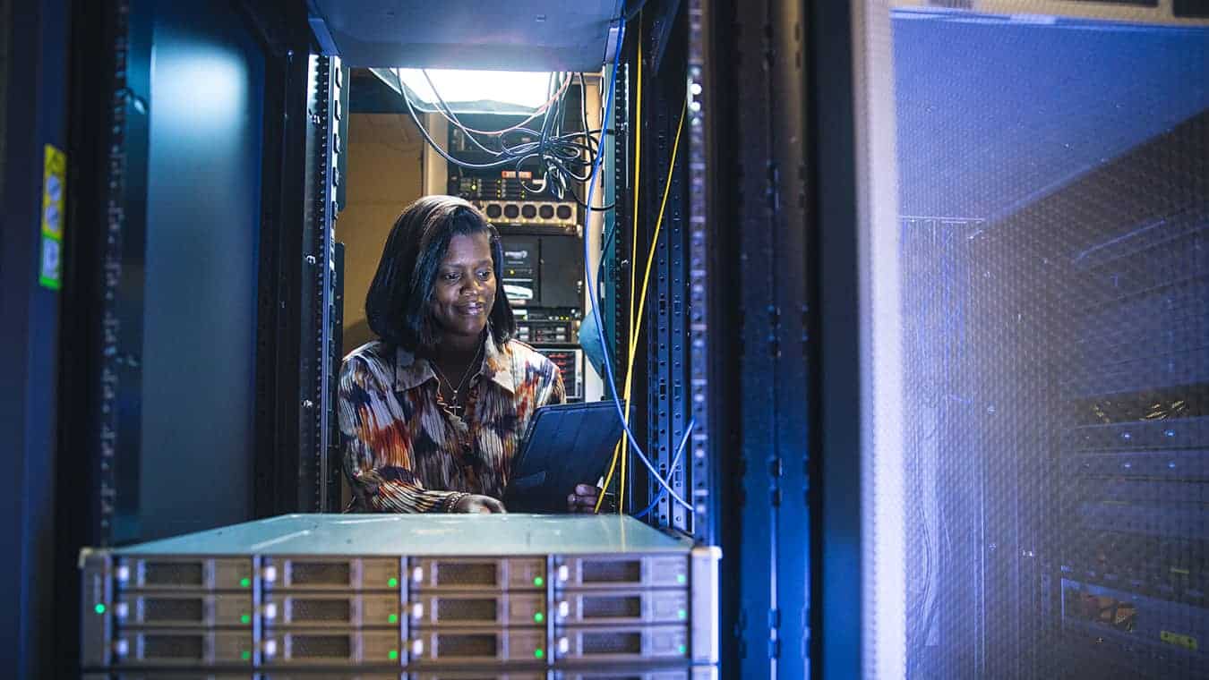 A lady in a server room: Pursue a Certificate of Graduate Studies in Cybersecurity Policy at Regent University.