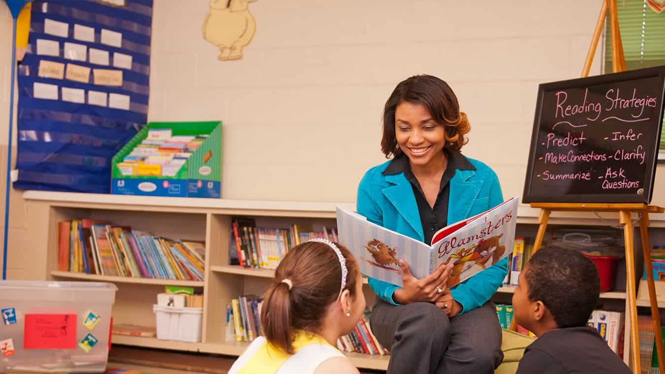 An alumna with students: A reading specialist degree program can be pursued at Regent University.