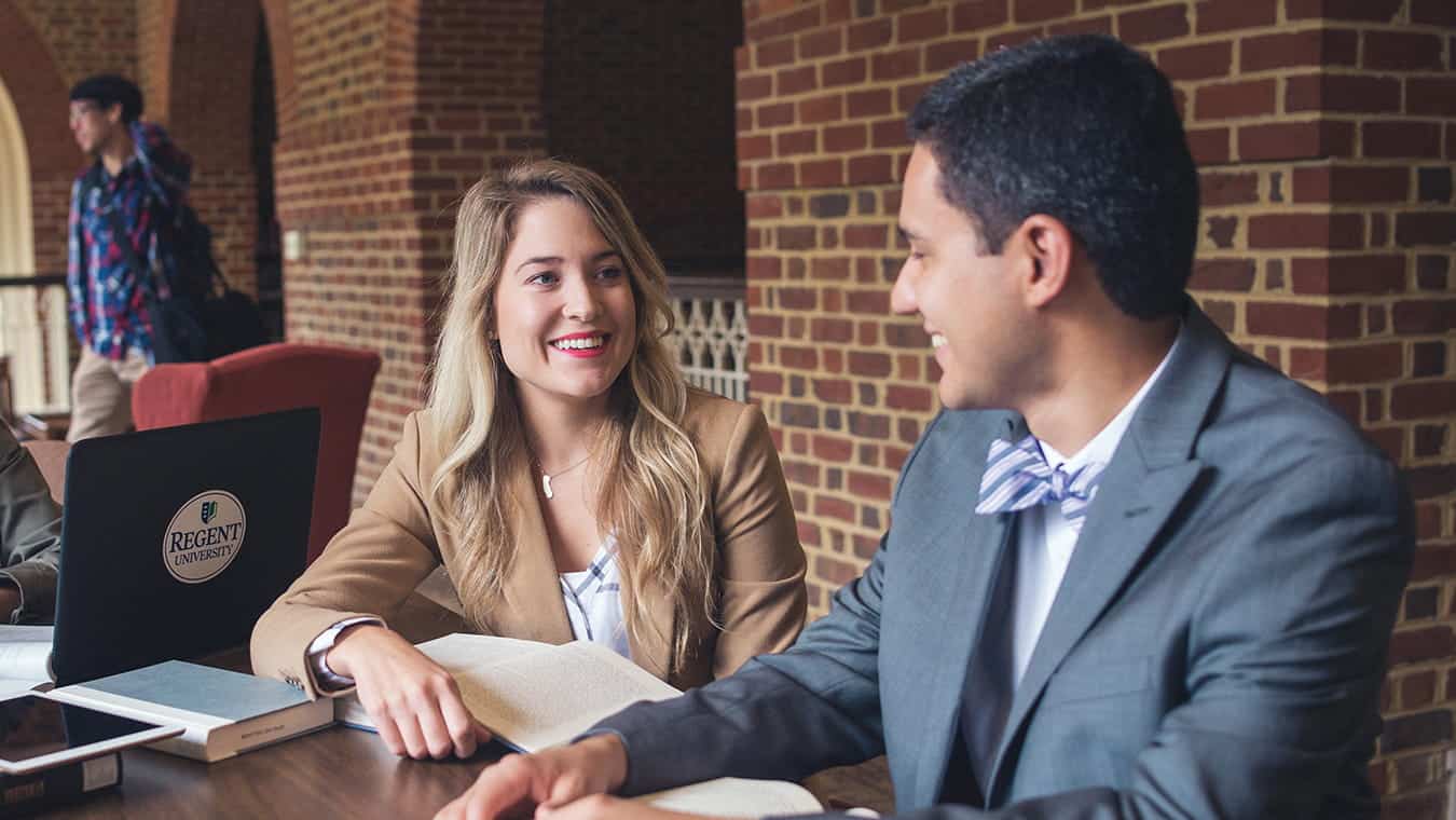 Two graduates at the library: Pursue your Christian leadership and management degree online at Regent University