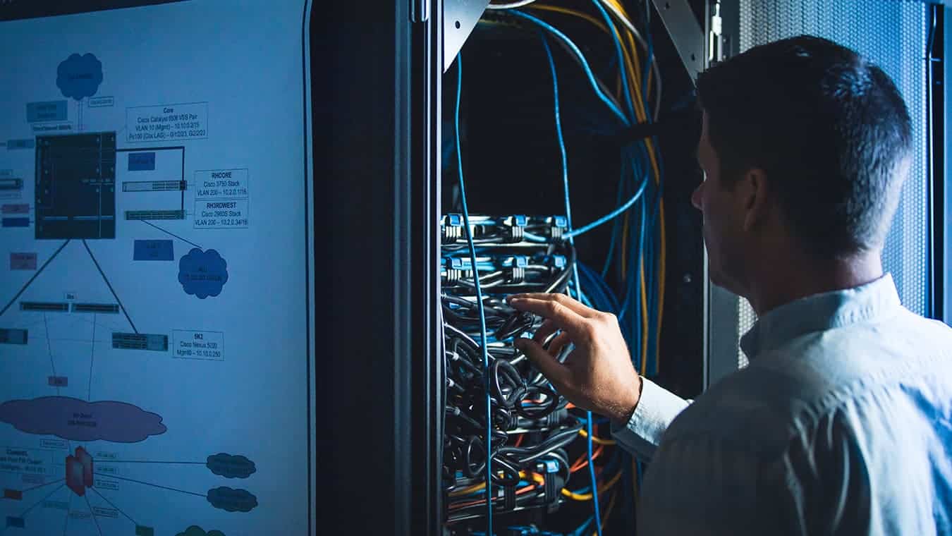 A person working in the server room: Pursue an Associate in Information Systems degree program at Regent University.