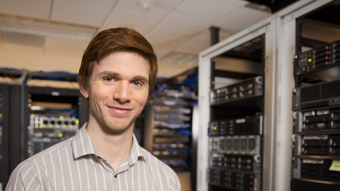 A person in a server room: Regent University offers an information systems minor online and in Virginia Beach, VA 23464.