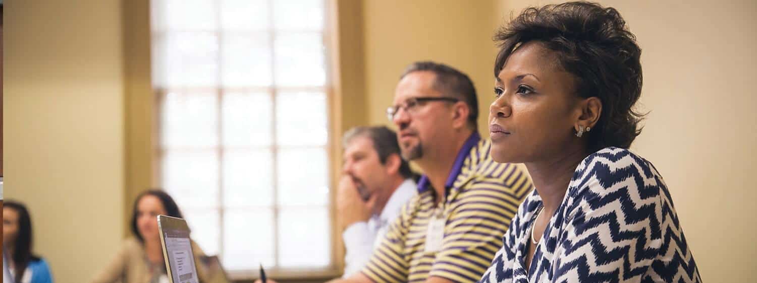 Students in a classroom: Pursue an online Ph.D. in Organizational Leadership at Regent University.