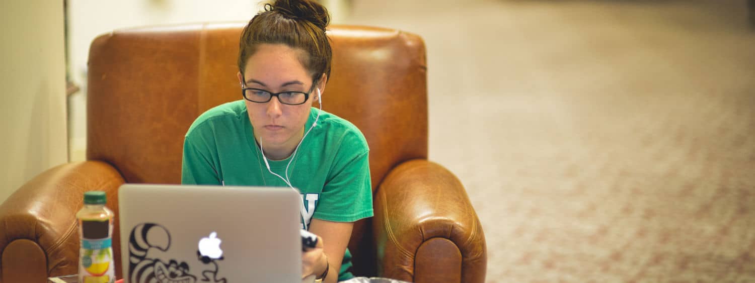 A student works on her laptop at Regent University's library in Virginia Beach.