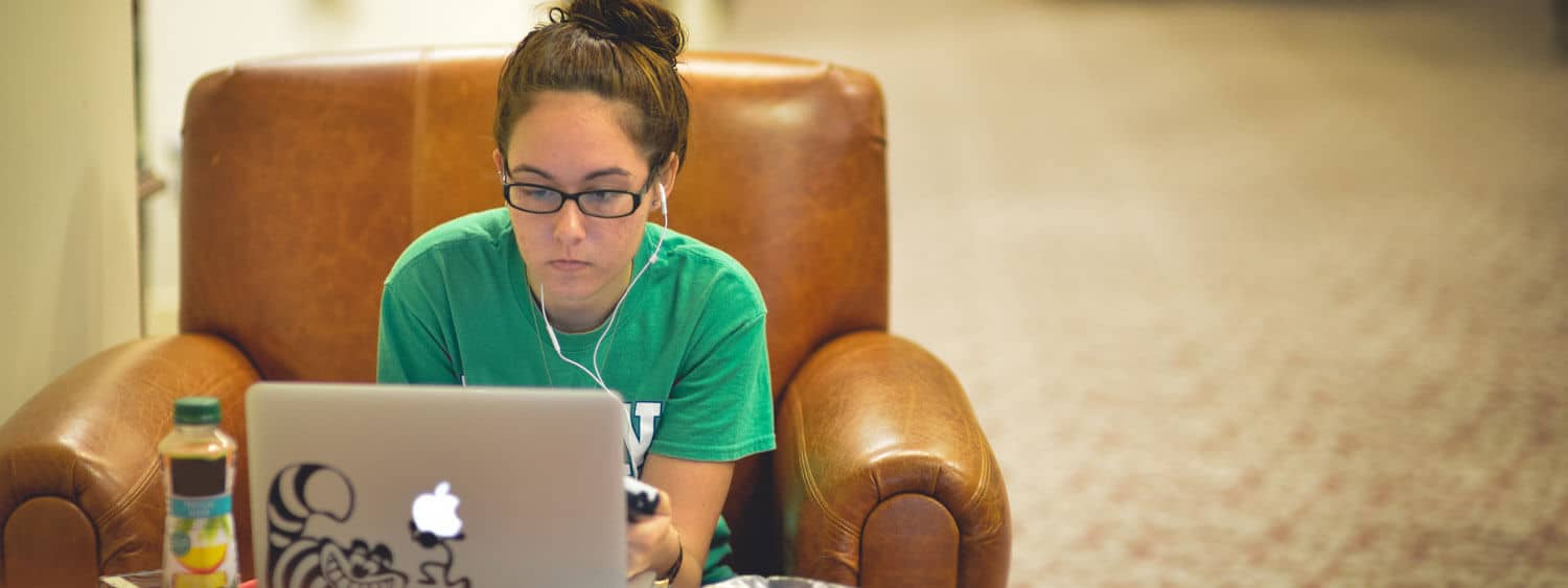 Student working on her laptop in the library.