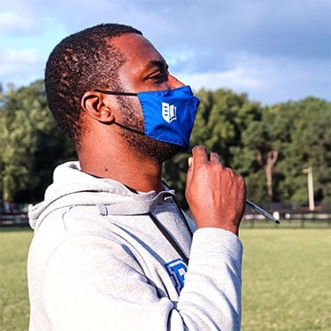 A member of the Regent University community wearing a protective face mask.