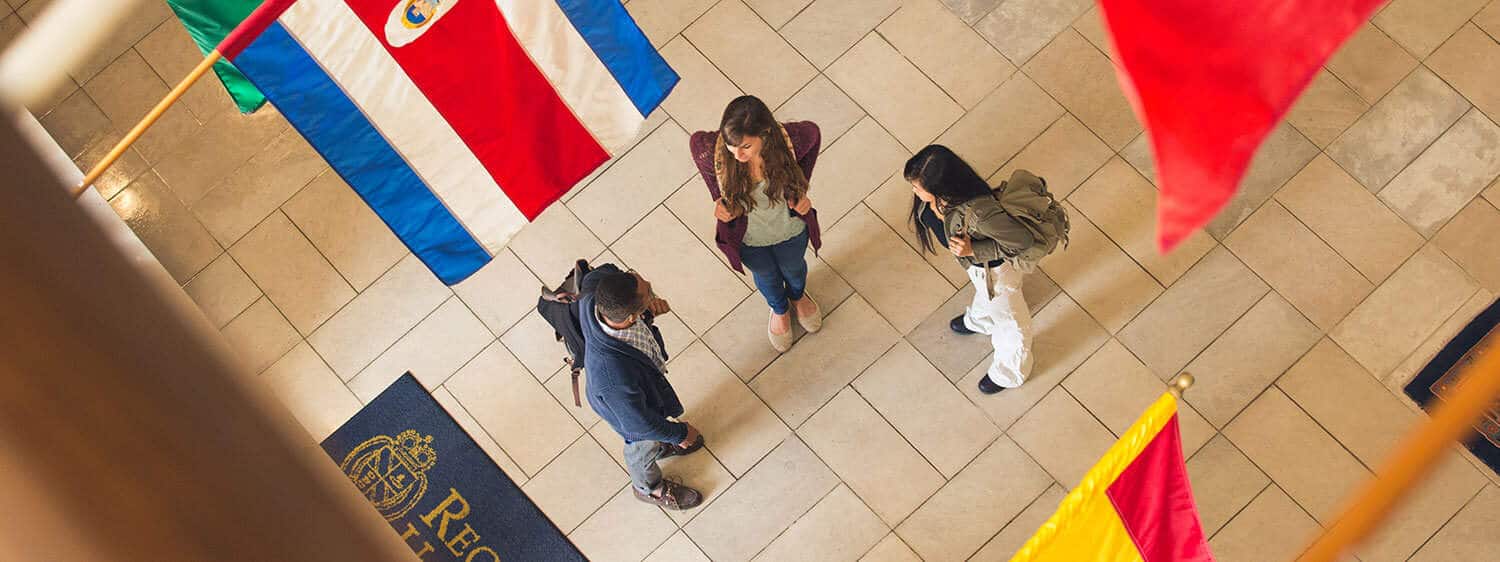 Students at the foyer of Regent University's library, which bears flags of our international students' countries.