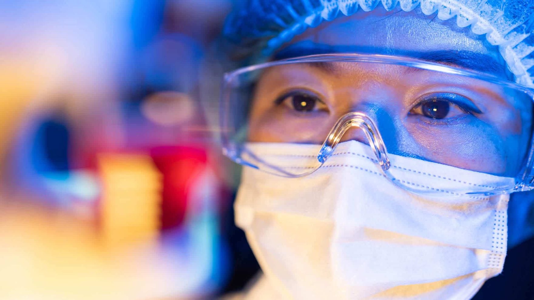 A person wearing a mask, visor and medical cap: Explore Regent's B.S. in Biophysical Sciences - Biomedical/ Pre-Med program.