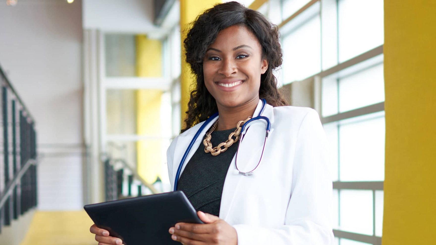 A doctor holding a tablet: Explore the MSN-APRN degree program at Regent University.