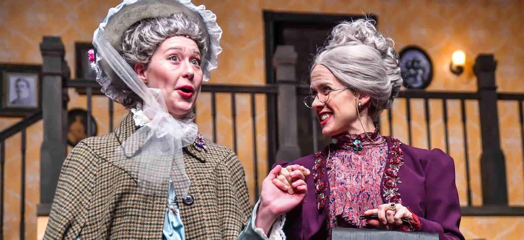 Two Regent University students costumed as elderly women perform on stage.