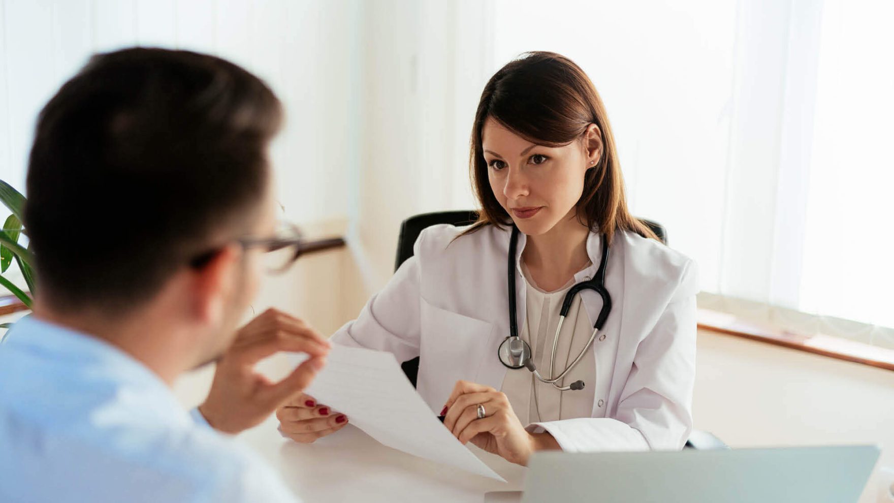 A doctor reviews a document with a patient: Explore Regent's Psychiatric Mental Health Nurse Practitioner (PMHNP) program.
