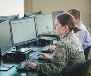 A military woman works on the computer in the Cyber Range at Regent University.