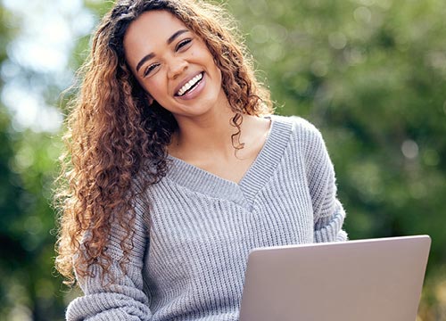Student smiling with her laptop: resources for parents of college students