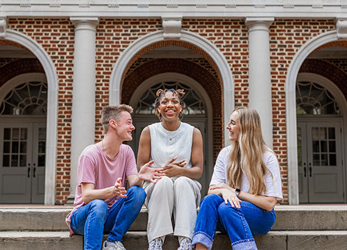 students sitting on stairs and smiling: resources for parents of college students