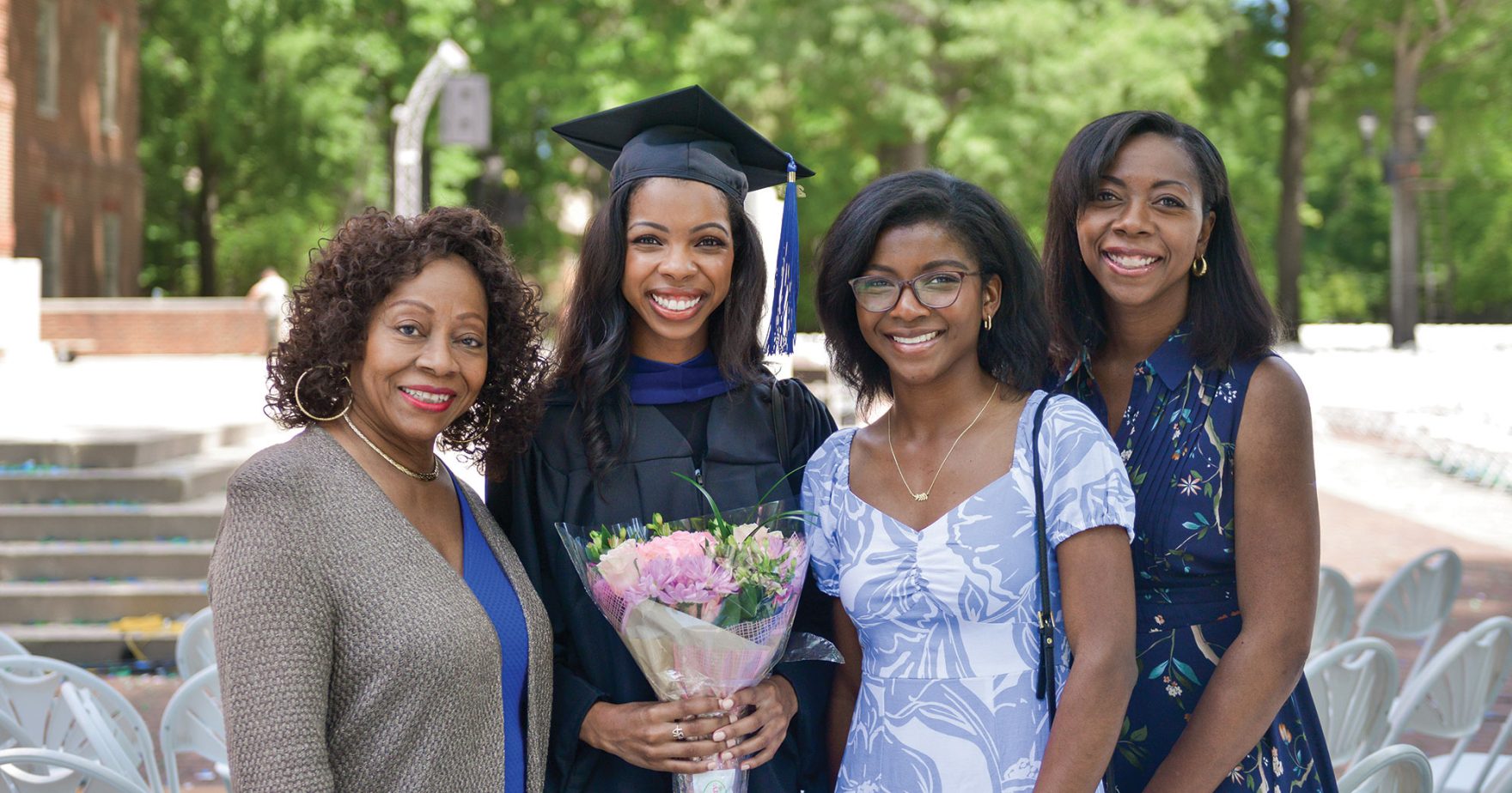 Recent graduate smiling with her parents: resources for parents of college students