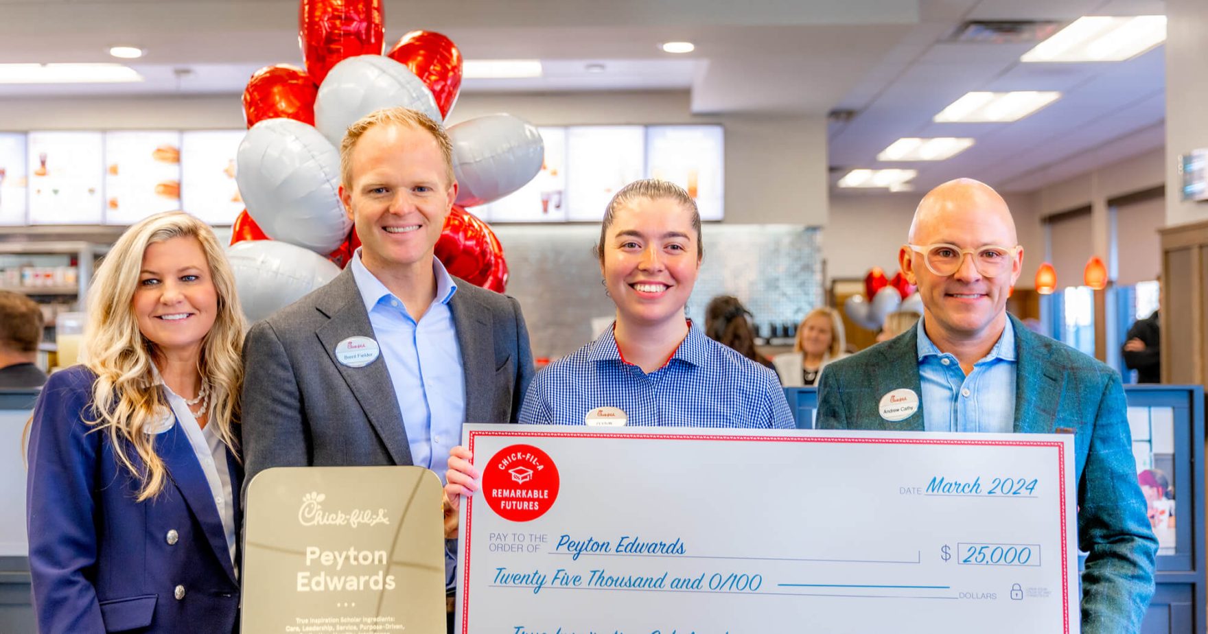 Regent University Student holding a large $25,000 Scholarship check with the CEO of Chick-fil-A