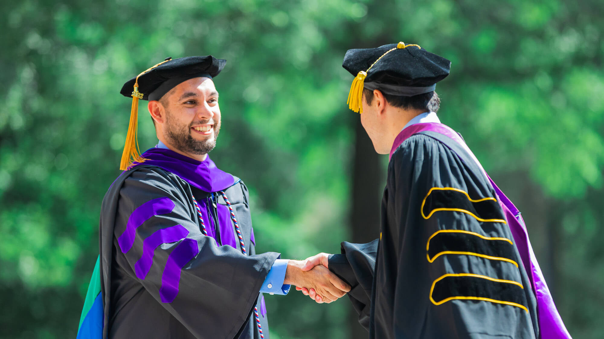 A graduate shaking a professor's hand of Regent University Law Schools in Virginia Beach, Virginia.