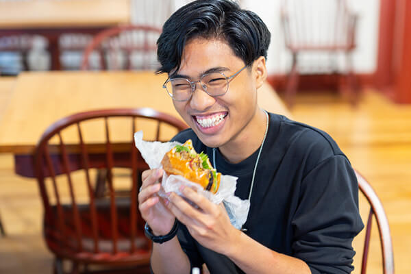 Student eating at the Ordinary Cafe, Regent's campus dining service, in Virginia Beach
