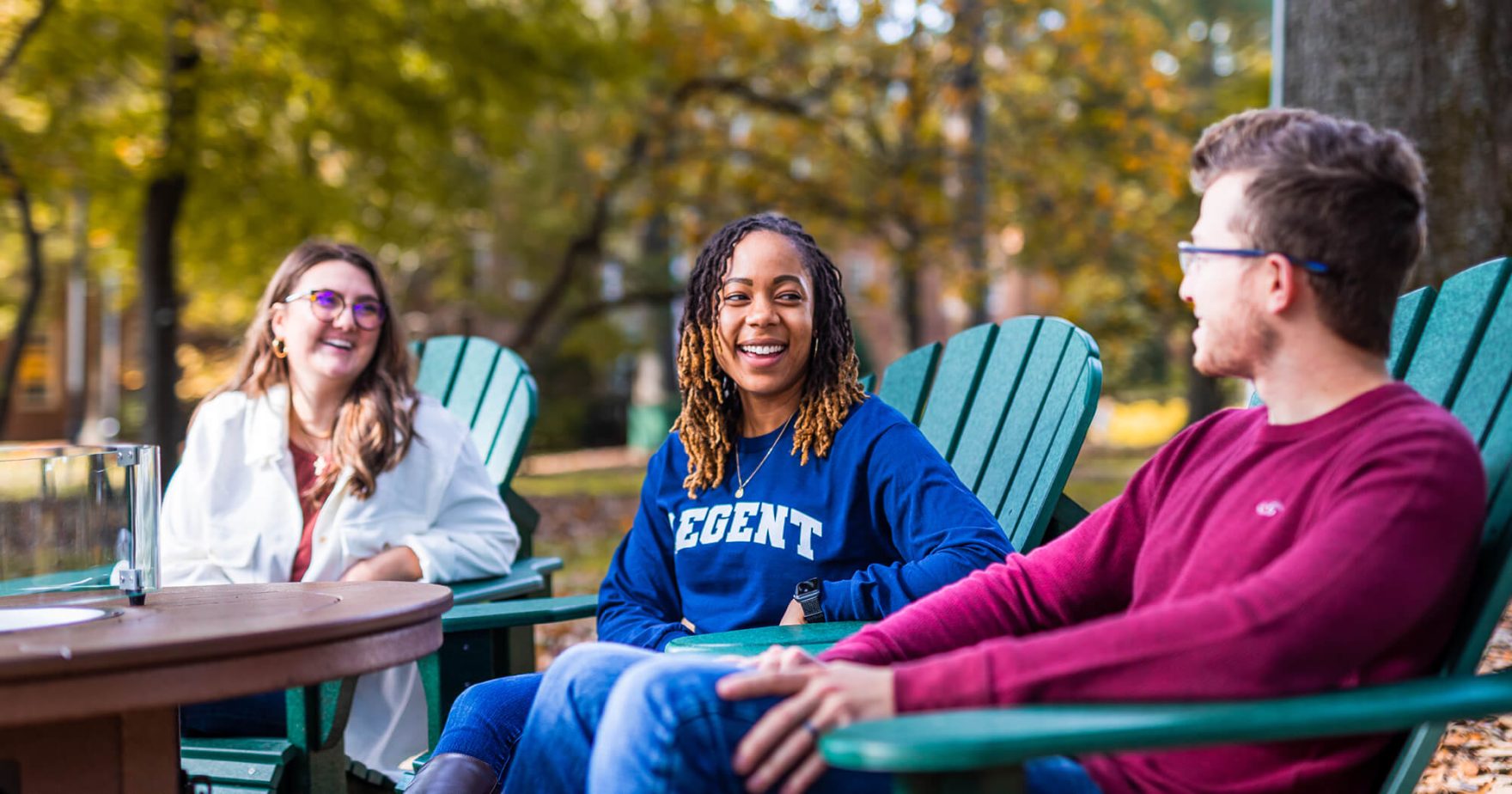 Three Regent University students sitting on campus in Virginia Beach, Virginia.
