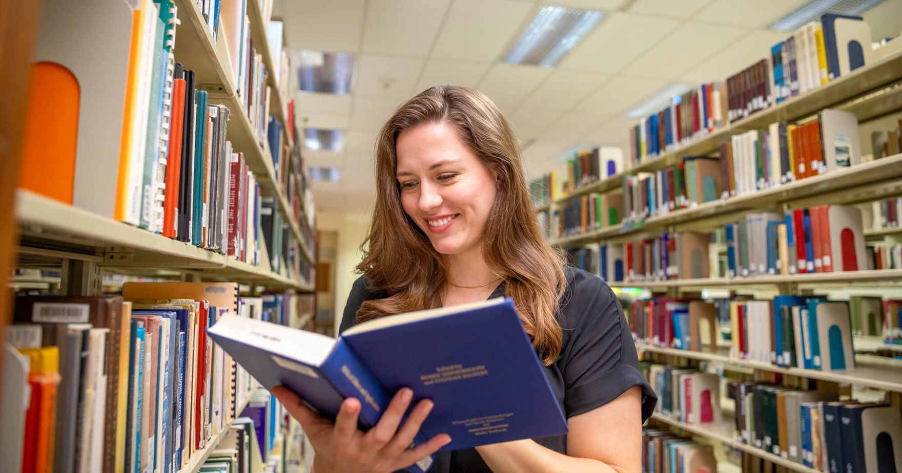 College student reading a book at the Regent University Library in Virginia Beach, Virginia.