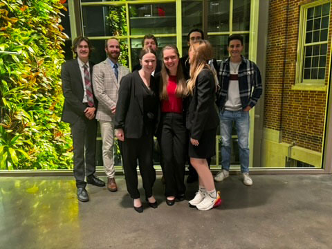Student holding a humorous Moot Court 2024 certificate in a classroom