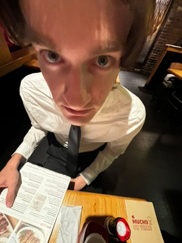 Three students taking a fun selfie in a crowded hall after competition