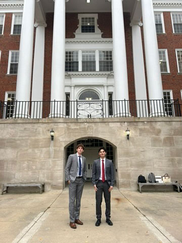 Student stepping out of a white van at night with arms stretched wide