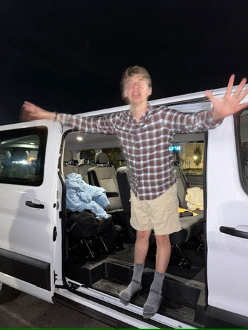 Two students in suits standing in front of a university building