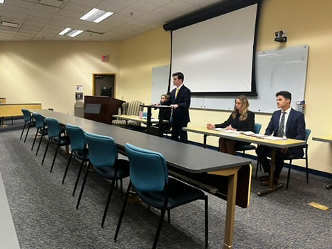 Moot Court team celebrating with awards in front of a Liberty University School of Law backdrop