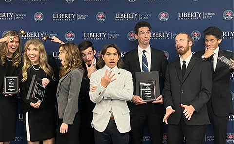 Student advocate delivering oral argument at a lectern with teammates