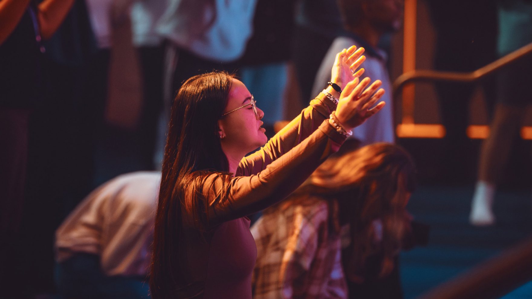 Student worshipping at Regent University; learn why to choose a Christian college