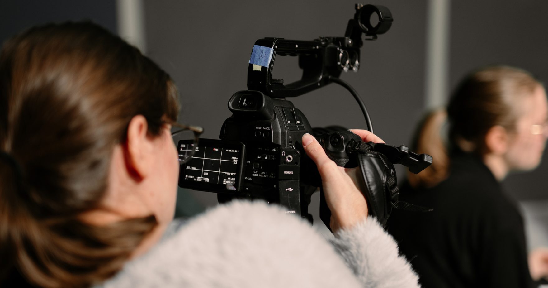 Regent University film student holding a camera on set at a film setup on campus at Virginia Beach, Virginia.