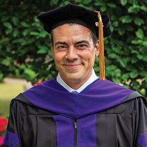 Joe Addink, Juris Doctor graduate, in academic regalia on Regent University’s campus.