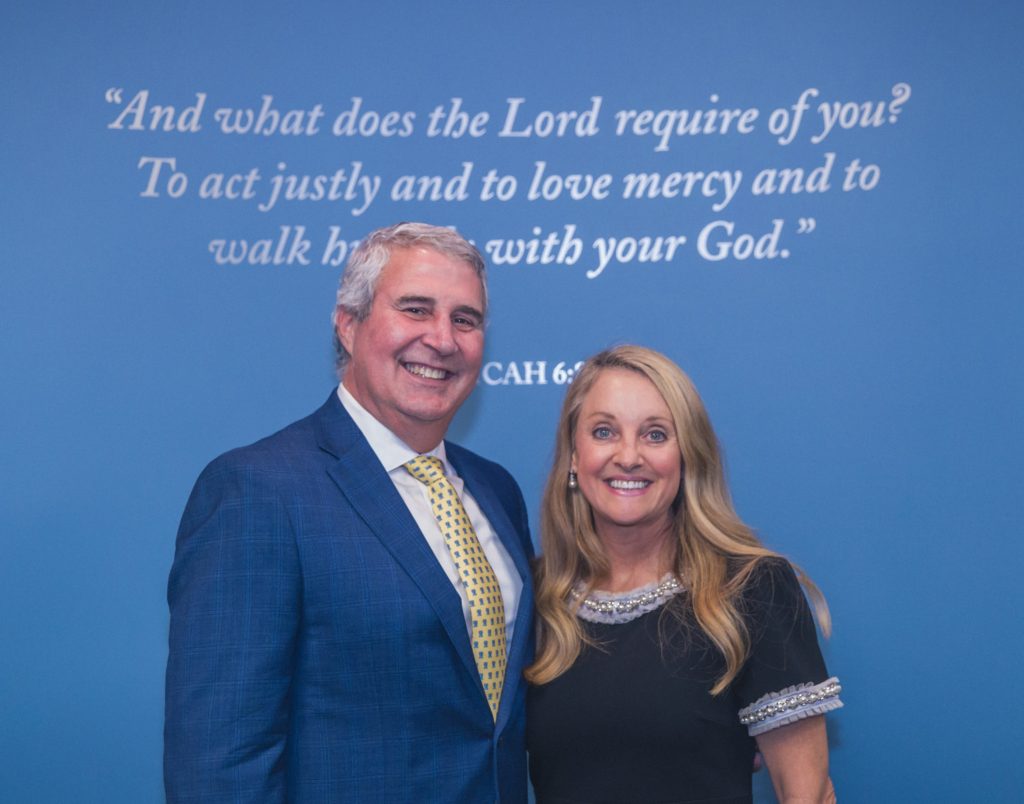John and Beverly Reese, benefactors of Regent University’s Grace Community Law Clinic, stand before a wall displaying Micah 6:8 at the clinic’s dedication ceremony.