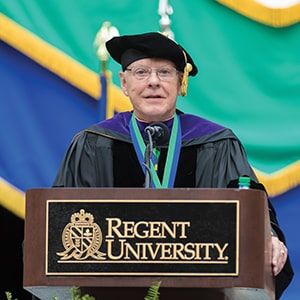Dr. Kenneth Eldred delivering commencement address at Regent University podium
