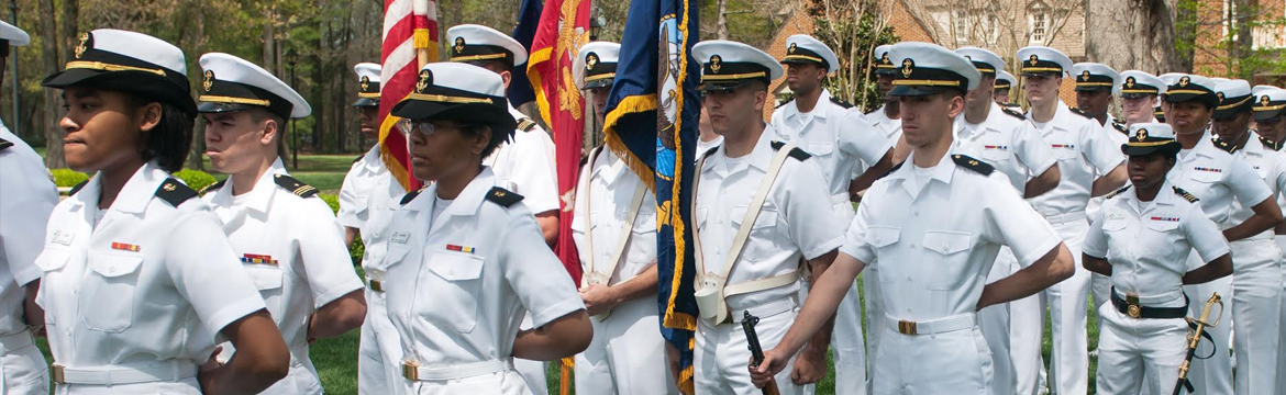 Military service members in dress white uniforms at formal ceremony