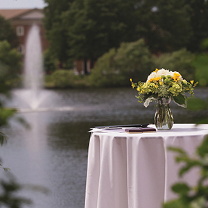 Yellow flower arrangement on table at Founders Inn with fountain in background