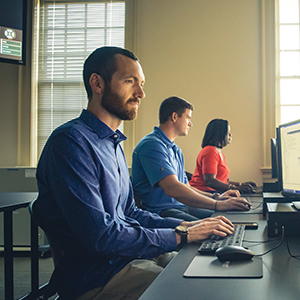 people at computer monitoring cyber attacks