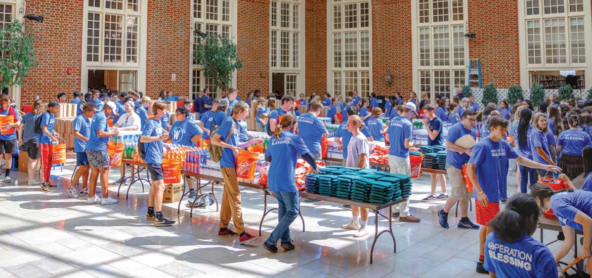 Regent University students and volunteers pack disaster-relief buckets during the Operation Blessing outreach held in the atrium.